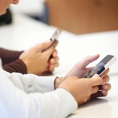 Jugendliche benutzen ihre Handys in der Schule
