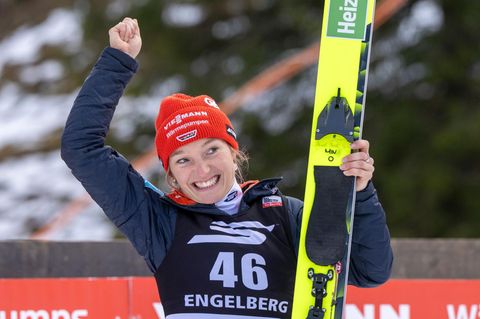 Skispringerin Katharina Schmid jubelt mit ihren Skiern in der linken Hand