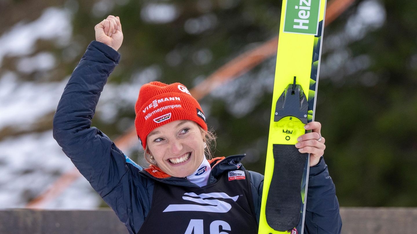 Skispringerin Katharina Schmid jubelt mit ihren Skiern in der linken Hand