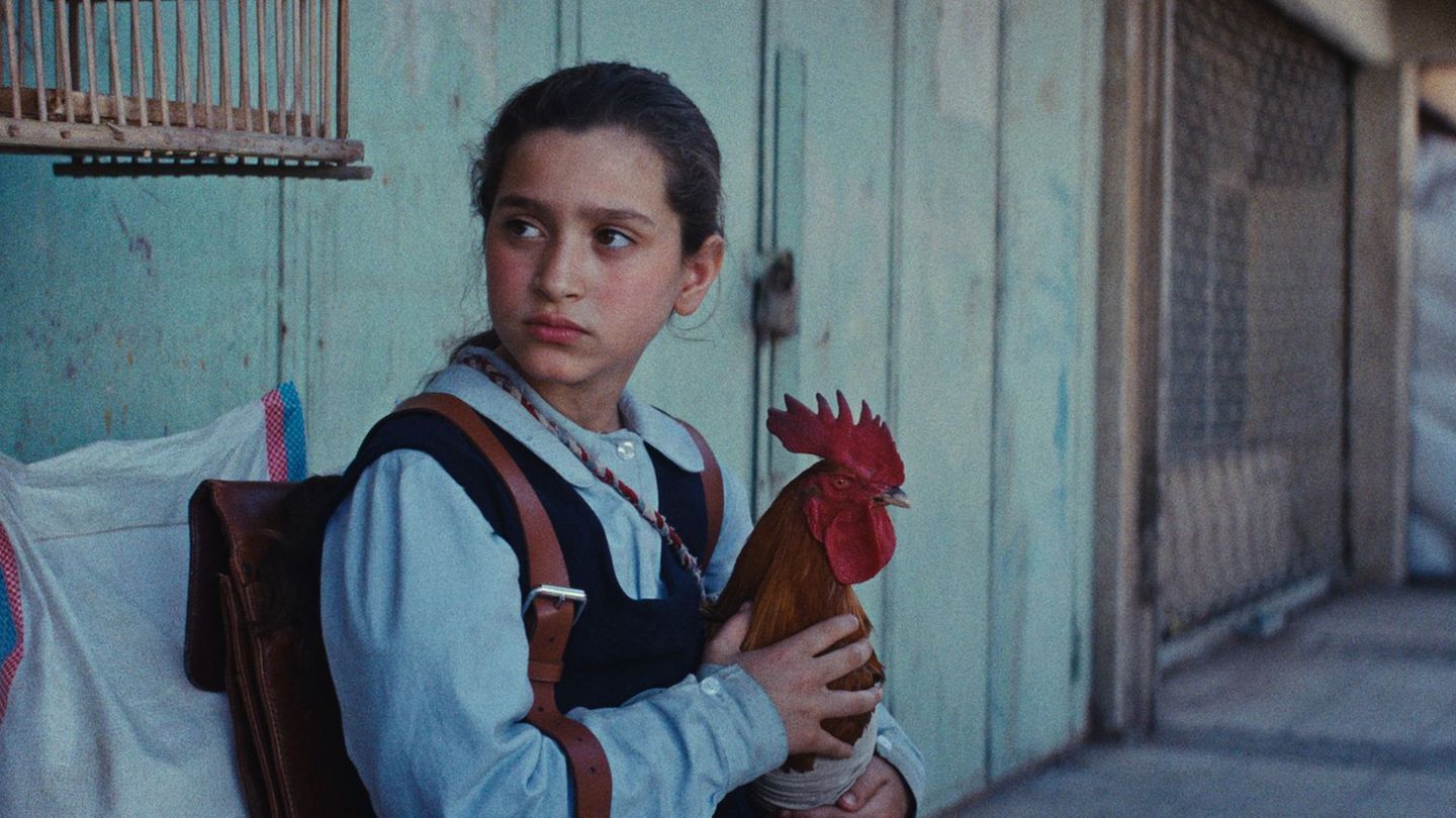 Lamia (Baneen Ahmed Nayyef) mit Hahn Hindi in einer Szene des Films "Ein Kuchen für den Präsidenten" (undatierte Filmszene). Fot