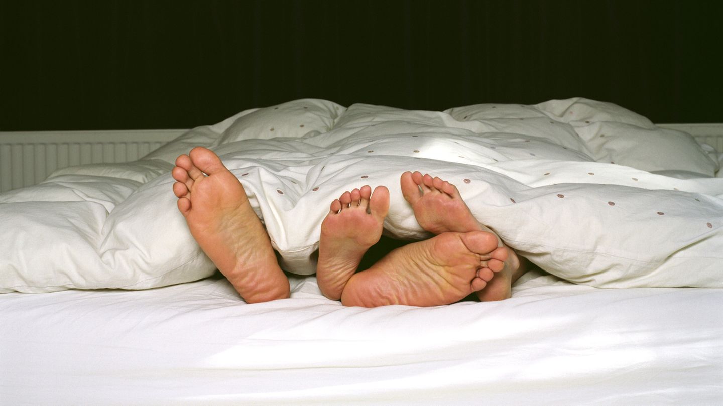 Zwei Fußpaare schauen unter der Decke heraus