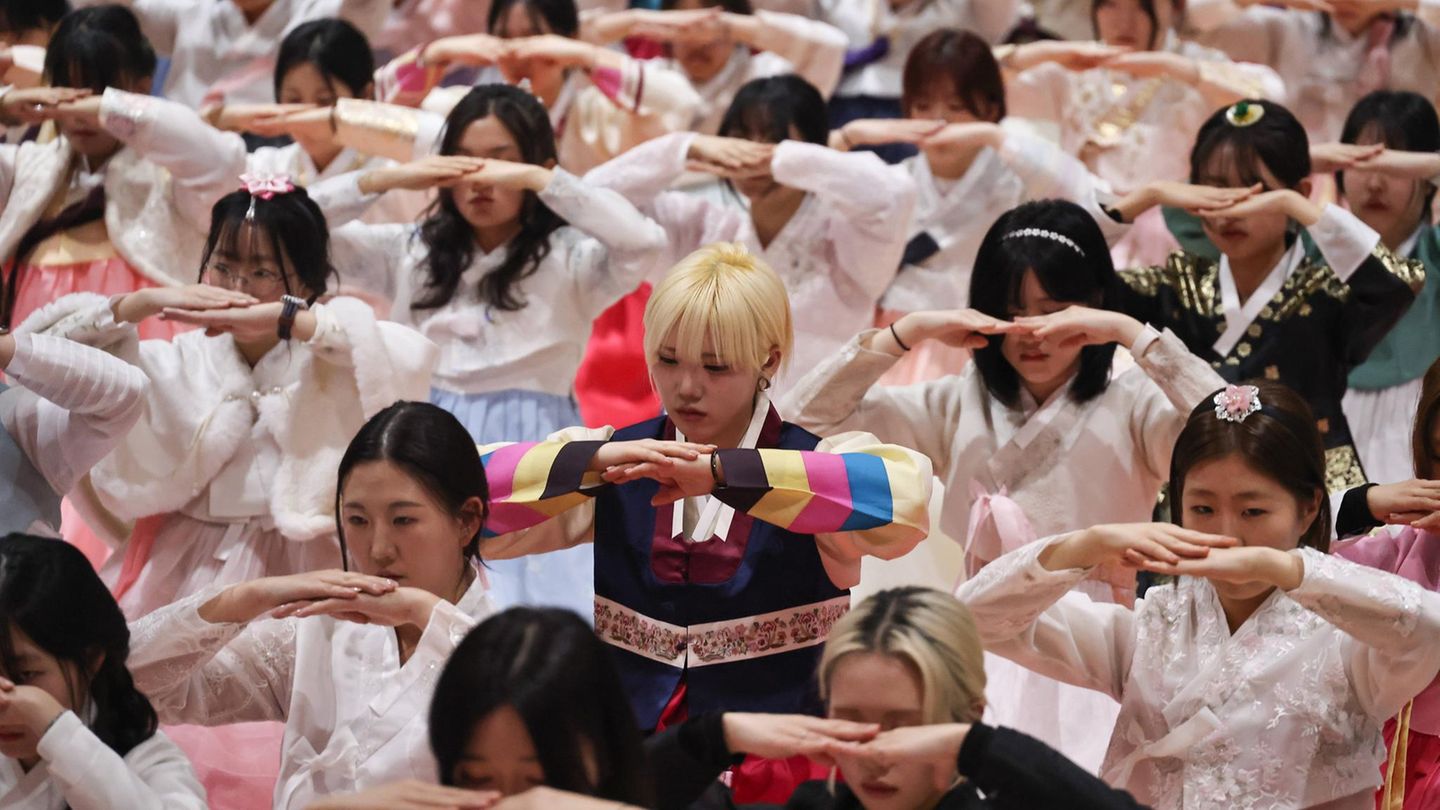 Schülerinnen feiern in traditioneller Kleidung ihren Schulabschluss