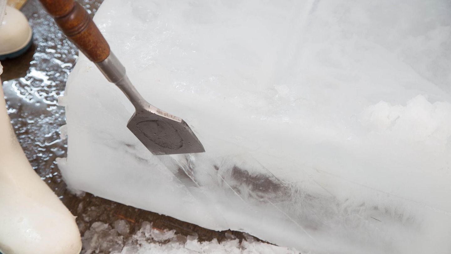 Ein Mann schabt Eis mit dem Eisschaber