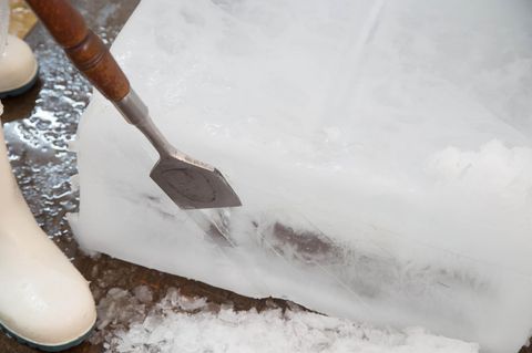 Ein Mann schabt Eis mit dem Eisschaber