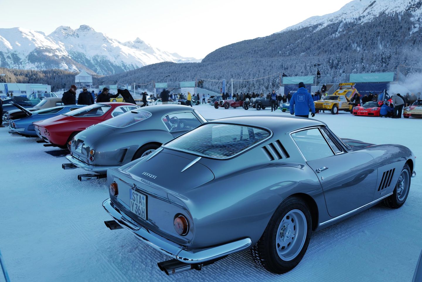 Ferrari 250 SWB von hinten neben weiteren Autos, im Hintergrund eine Bergkette