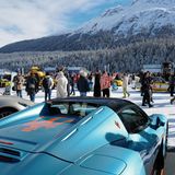 Luxusautos im Vordergrund, im Hintergrund Menschengruppen