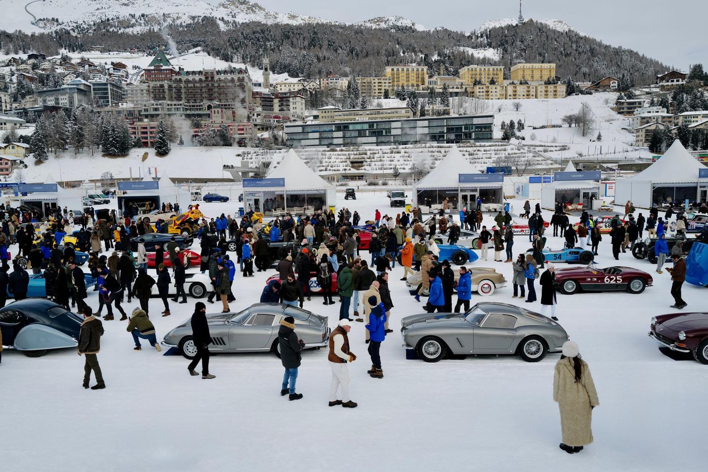 Vor dem Ort St.Moritz sammeln sich Autos und Menschen auf einem zugefrorenen See