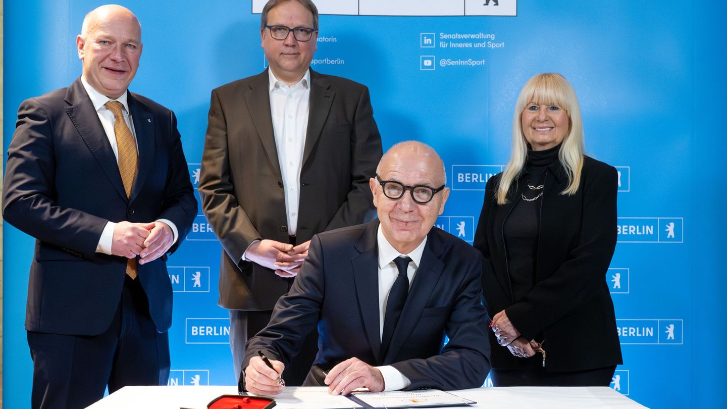 Bernd Neuendorf (vorne) bei der Unterzeichnung der Vereinbarung zum DFB-Pokal. Foto: Soeren Stache/dpa