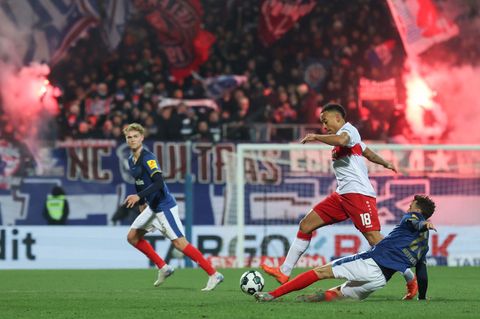 Stuttgarts Jamie Leweling und Kiels Jonas Meffert (r) kämpfen um den Ball. Foto: Christian Charisius/dpa