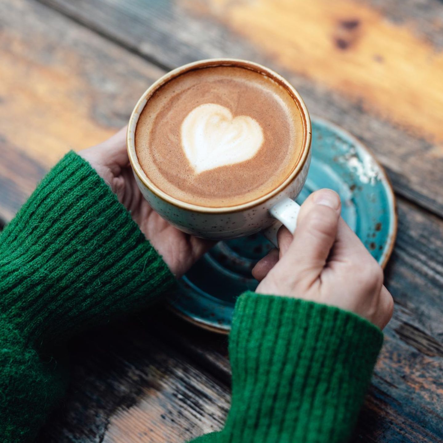 Zwei Hände und ein Cappucino
