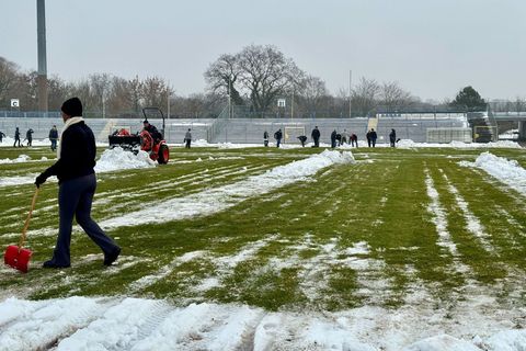 Freiwillige räumen Schnee von der Spielfläche im Dessauer Paul-Greifzu-Stadion Foto: Thomas Schulz/dpa