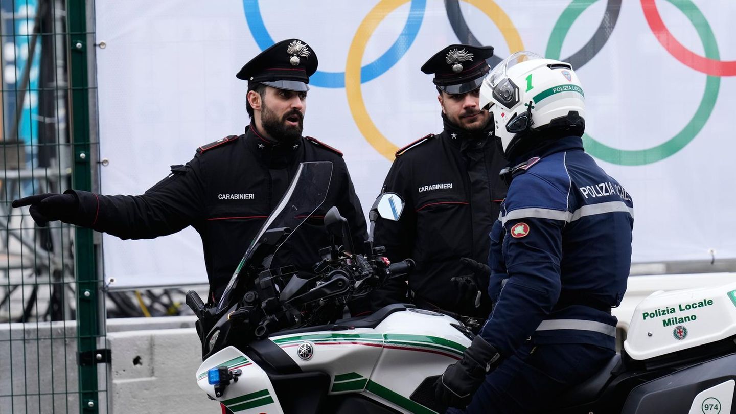 Italienische Polizisten sprechen vor dem Olympischen Dorf der Olympischen Winterspielen 2026