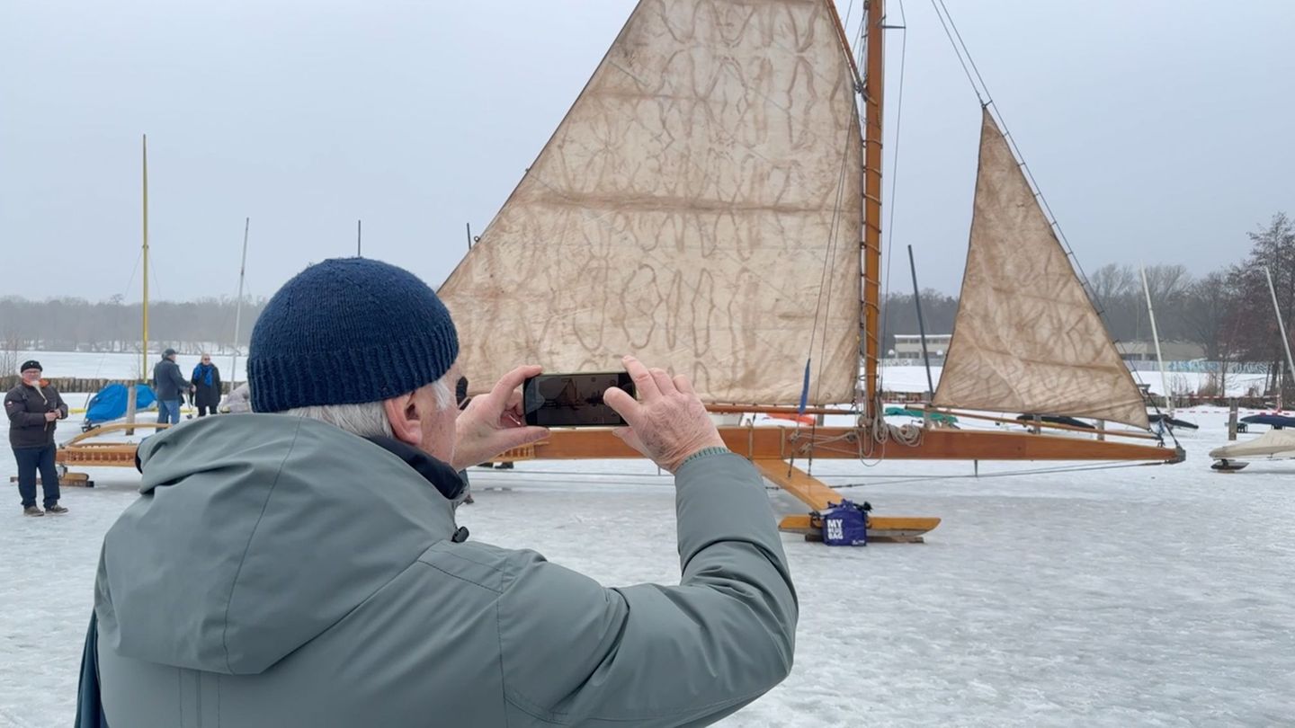 Ein Mann fotografiert auf dem zugefrorenen Müggelsee einen großen Eissegler. Foto: Lutz Deckwerth/dpa