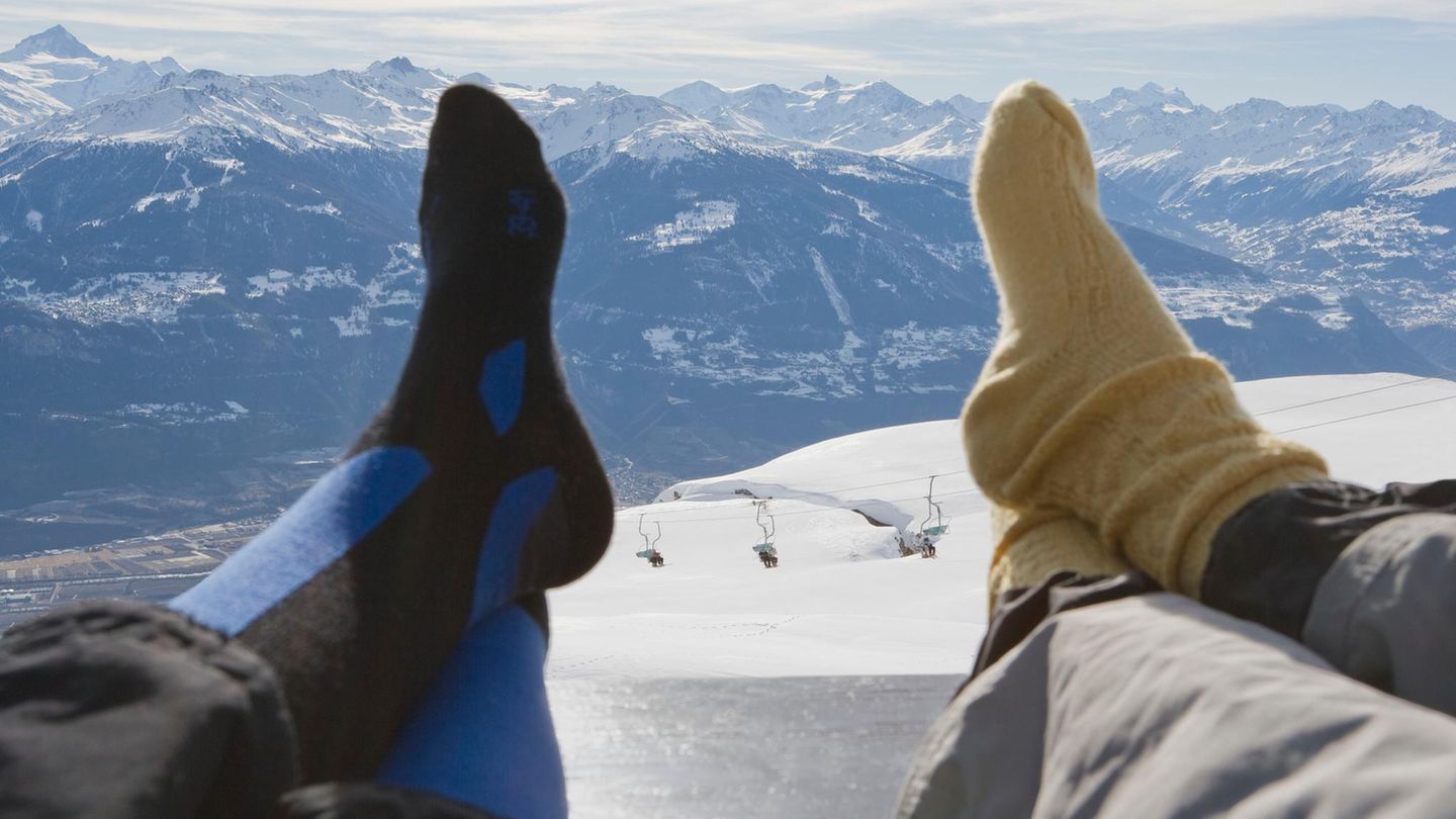Deal News: Zwei Skifahrer legen ihre Füße hoch und tragen Skisocken
