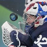 Frankreichs Eishockey-Torhüterin Alice Philbert hat den Puck, der mit hoher Geschwindigkeit auf sie zufliegt, fest im Blick