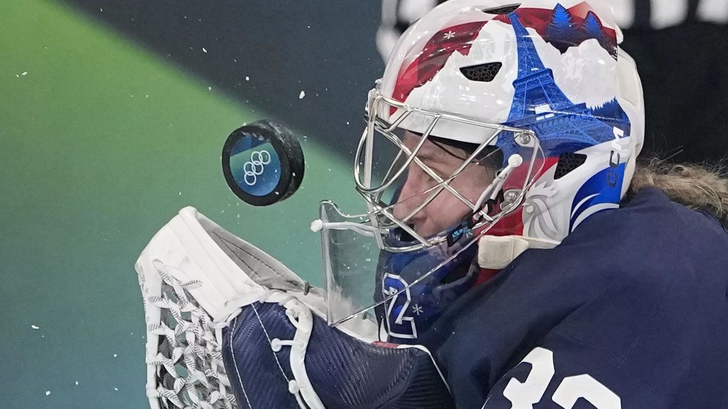 Frankreichs Eishockey-Torhüterin Alice Philbert hat den Puck, der mit hoher Geschwindigkeit auf sie zufliegt, fest im Blick