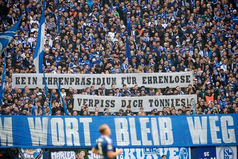 Fans zeigen Transparente mit der Aufschrift: "Kein Ehrenpräsidium für Ehrenlose. Verpiss dich Tönnies!". Foto: Bernd Thissen/dpa