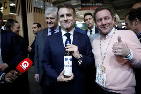 Emmanuel Macron mit Weinflasche
