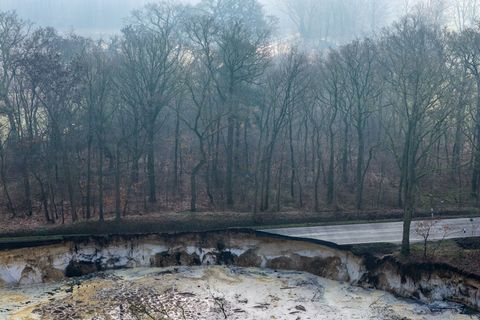 Direkt an einem Baggersee einer Quarzgrube sieht man auf dieser Drohnenaufnahme den abgesackten Bereich einer Straße. (Archivbil