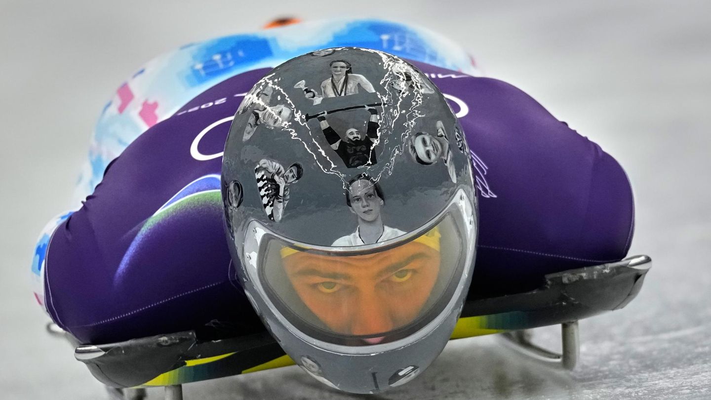 Der Ukrainer Wladislaw Heraskewytsch zeigt auf seinem Helm Porträts gefallener Sportler.
