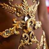 Nahaufnahme des Kostüms von Sabrina Ginga, es glänzt golden und ist mit Edelsteinen verziert