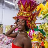 Eine Frau lacht, sie hat eine rot-goldene Kopfbedeckung auf