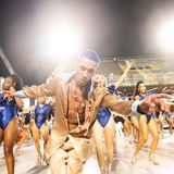 Eine Sambaschule setzt auf die Farbe blau, ein Tänzer in der Gruppenmitte hat blau gefärbte Haare, er schaut in die Kamera