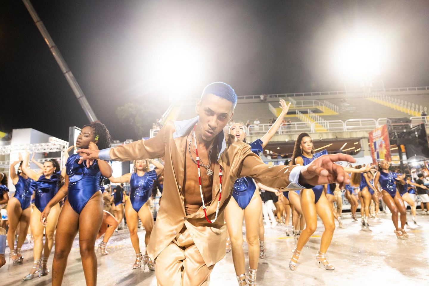 Eine Sambaschule setzt auf die Farbe blau, ein Tänzer in der Gruppenmitte hat blau gefärbte Haare, er schaut in die Kamera