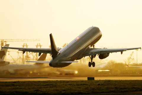 Ein startender Airliner vor gelbem Hintergrund, andere Flugzeuge sind im Hintergrund erkennbar