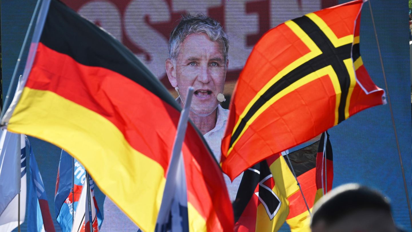 Deutschland-Fahnen wehen vor einer Bühne mit Höcke-Auftritt