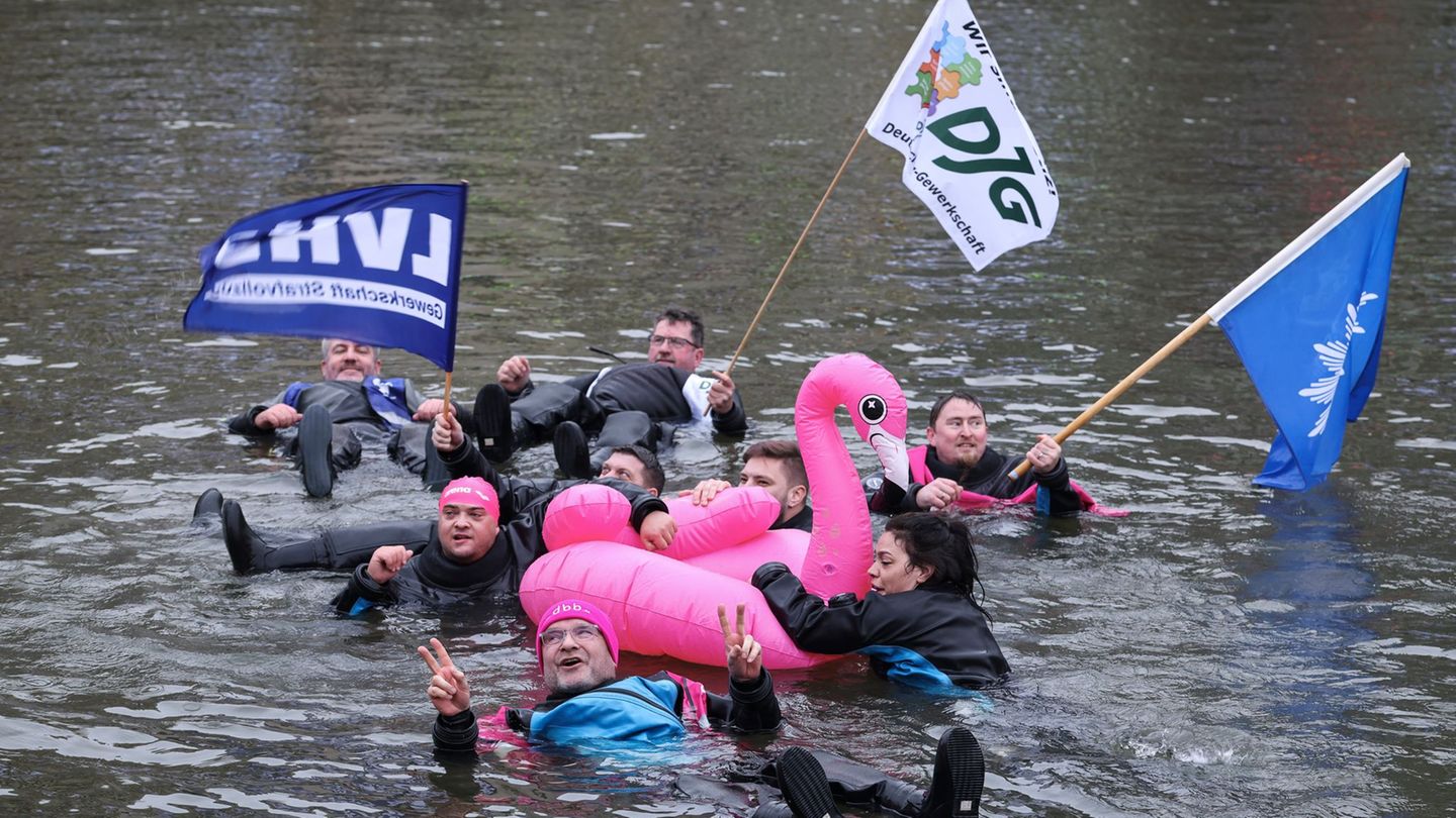 Demonstranten schwimmen in der kalten Elbe. Foto: Christian Charisius/dpa