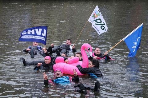 Demonstranten schwimmen in der kalten Elbe. Foto: Christian Charisius/dpa
