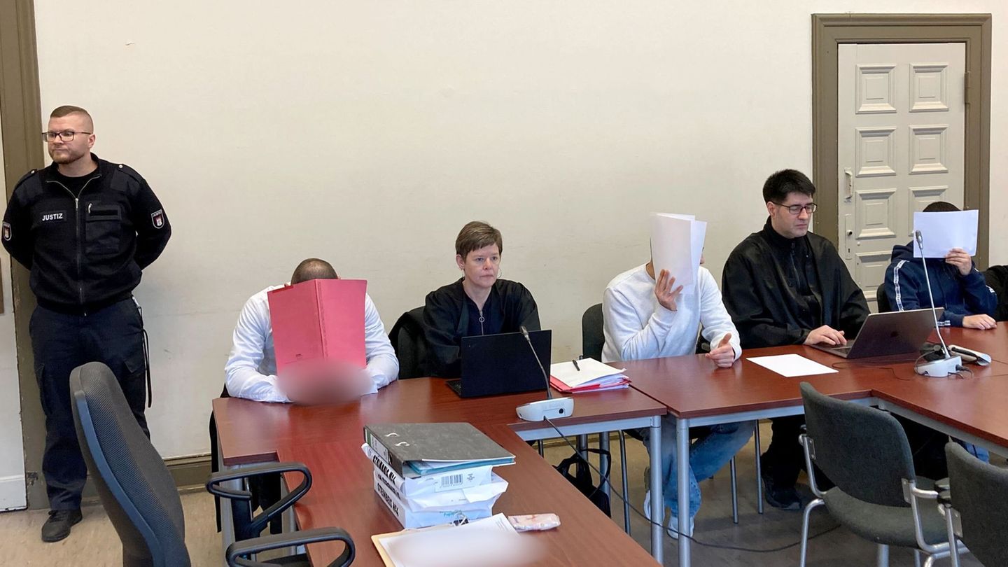 Die drei wegen versuchten Mordes angeklagten Männer verbergen ihre Gesichter vor den Kameras der Pressevertreter. Foto: Bernhard