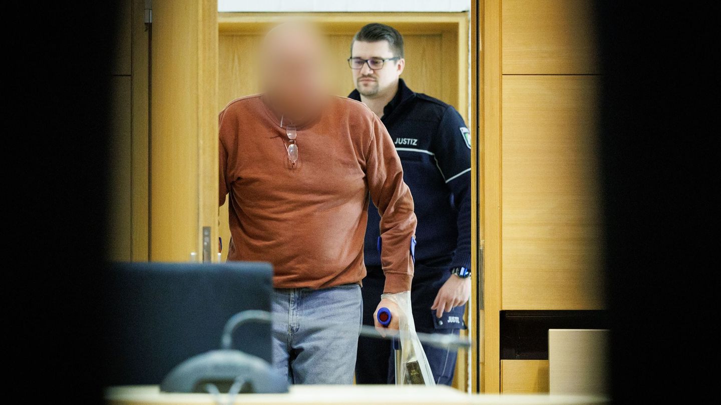 Der Angeklagte kommt in Begleitung eines Justizbeamten in den Prozesssaal am Landgericht Bielefeld. Foto: Friso Gentsch/dpa
