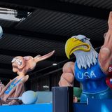 Motivwagen: Starke Tiere hinter dünnem Hasen mit "EU"-Shirt, der versucht ein kleines Gewicht zu heben