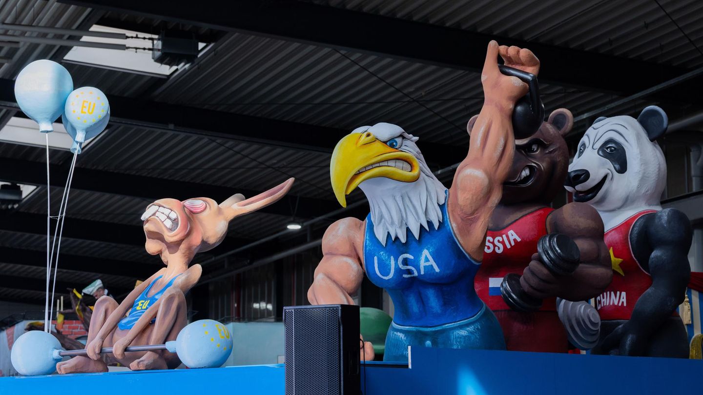 Motivwagen: Starke Tiere hinter dünnem Hasen mit "EU"-Shirt, der versucht ein kleines Gewicht zu heben