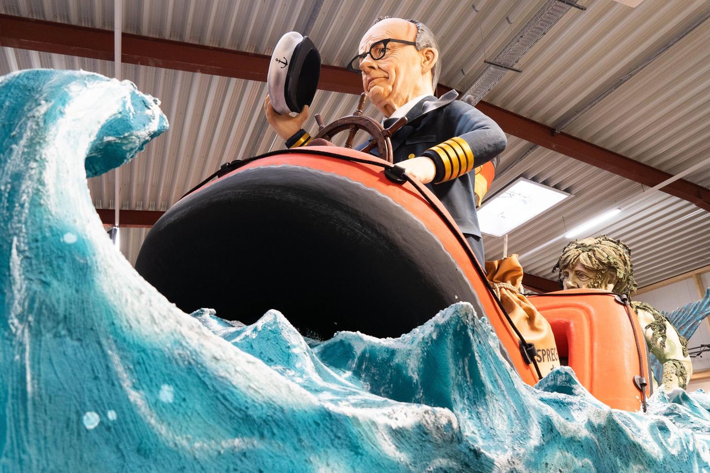 Motivwagen: Merz im Kapitänsanzug auf sinkendem Schlauchboot