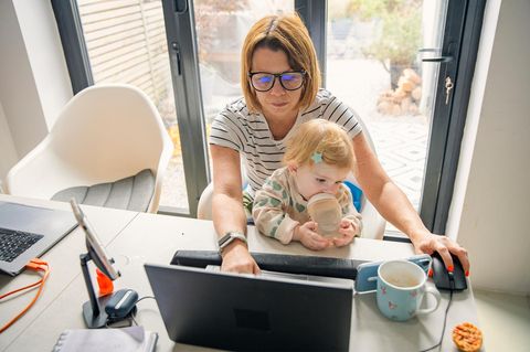 Einkommensteuer: Das Bild zeigt eine Mutter mit Kind vor Computer