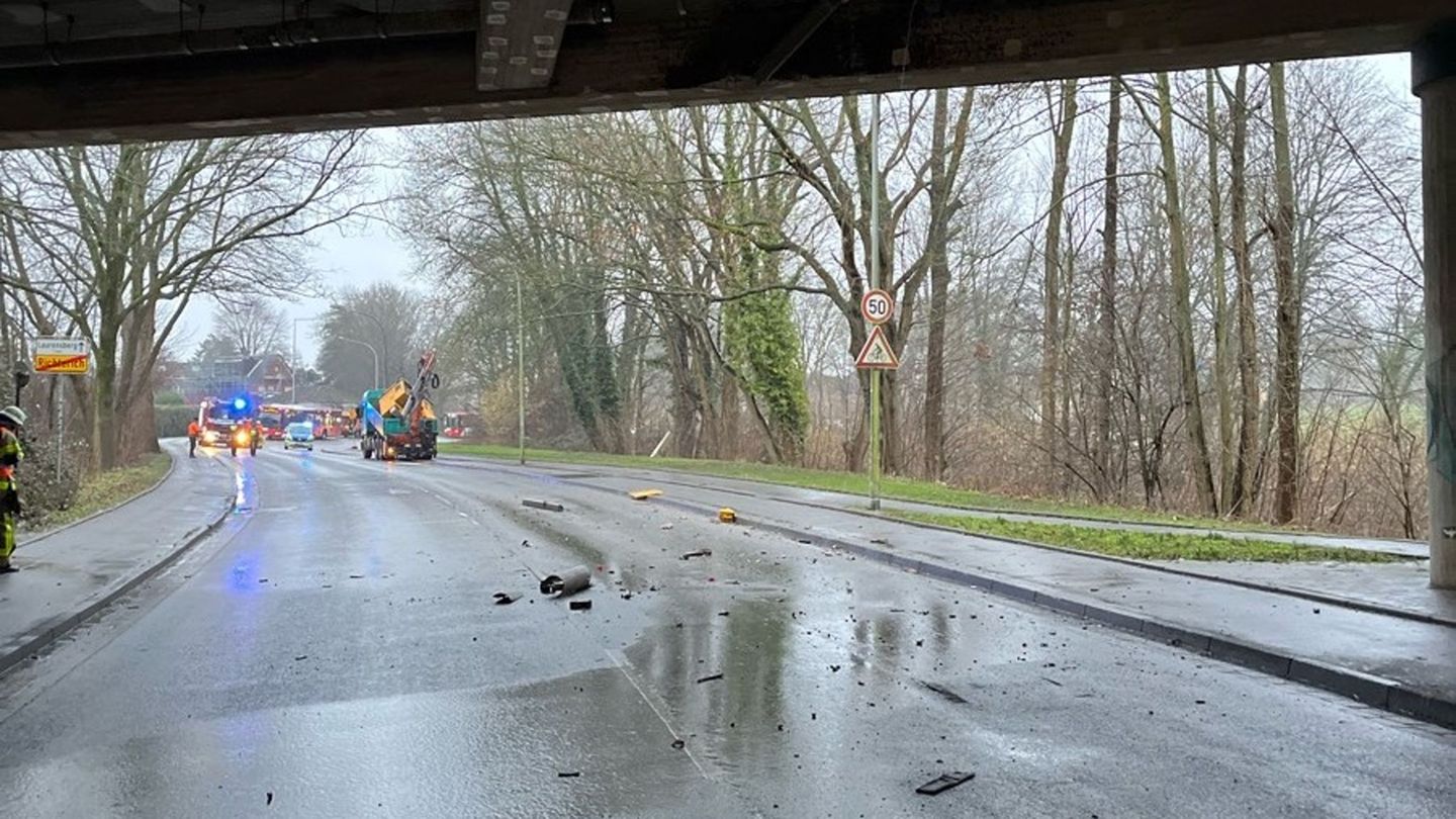 Trümmerteile liegen auf einer Straße. Ein Lkw ist mit seinem Kranarm gegen die Decke einer Unterführung der A4 bei Aachen gestoß