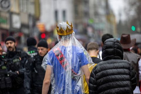 Regencape mit Krone: Die rheinischen Narren mussten an Weiberfastnacht tapfer sein. Foto: Thomas Banneyer/dpa
