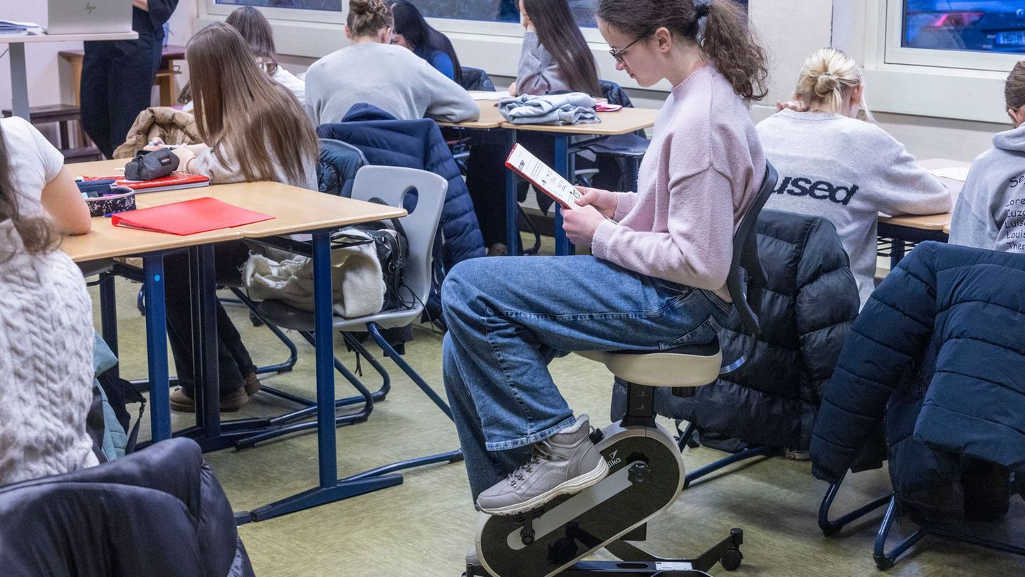 Deutschlektüre mit Bewegung: Eine Schülerin tritt mit den Füßen in die Pedale und liest gleichzeitig. Foto: Helmut Fricke/dpa