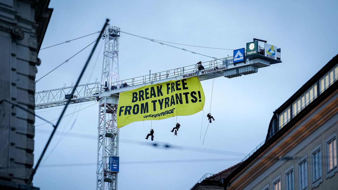 Aktivisten seilen sich von einem Kran in der Nähe der Münchner Sicherheitskonferenz ab. Foto: Kay Nietfeld/dpa