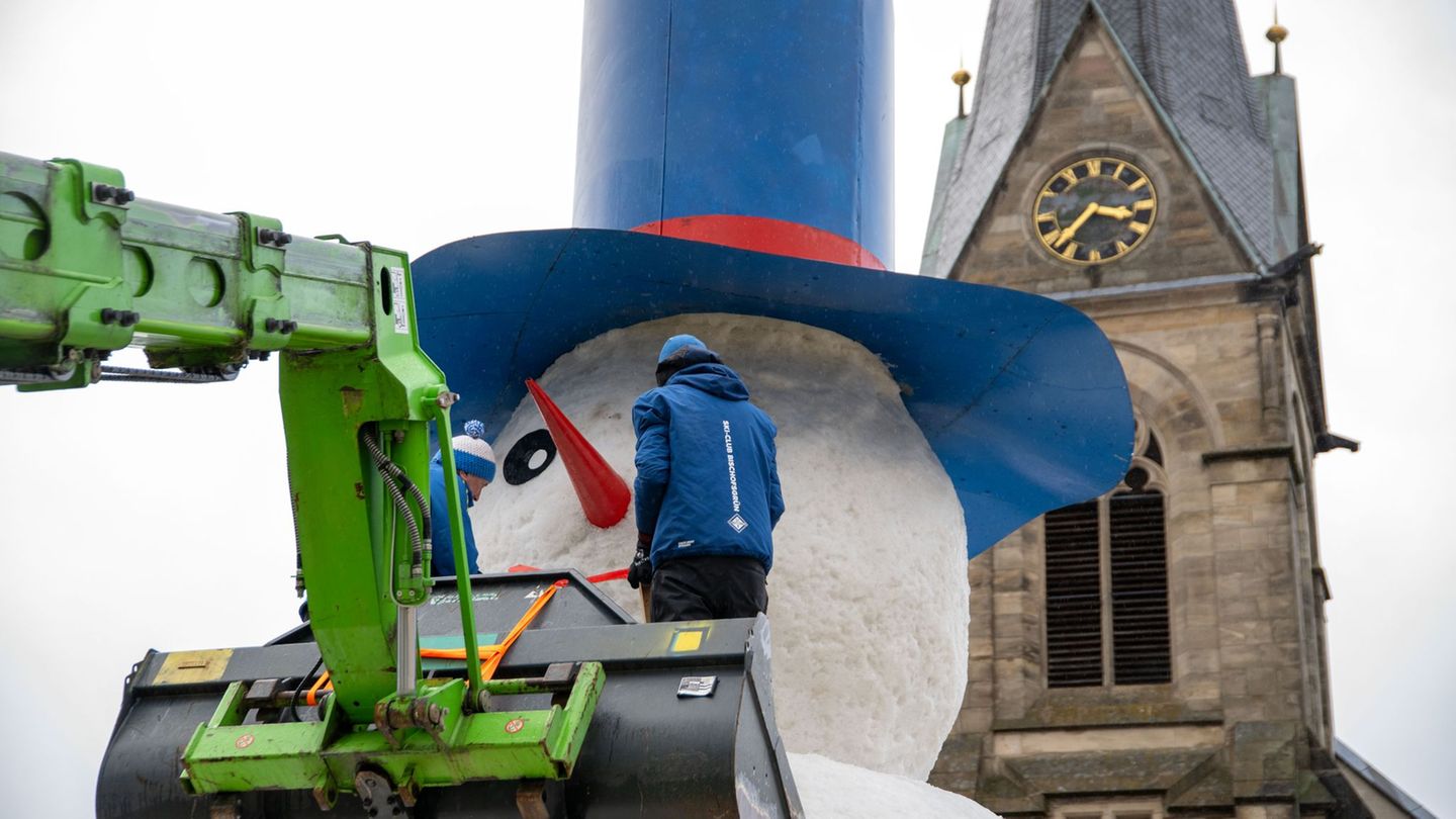 Feinschliff für den Schneemann "Jakob". Foto: Pia Bayer/dpa