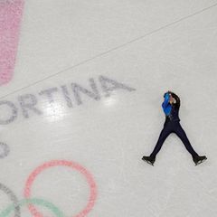 Michail Schaidorow aus Kasachstan liegt nach seiner Kür auf dem Eis – und da weiß er noch gar nicht, dass er wenig später durch Patzer von US-Wunderkind Ilia Malinin Olympiasieger wird