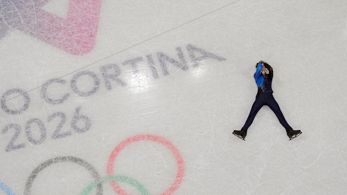 Michail Schaidorow aus Kasachstan liegt nach seiner Kür auf dem Eis – und da weiß er noch gar nicht, dass er wenig später durch Patzer von US-Wunderkind Ilia Malinin Olympiasieger wird.
