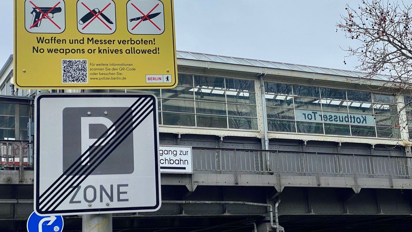 Gelbe Schilder weisen auf die Waffen- und Messerbotszone am Kottbusser Tor in Berlin-Kreuzberg hin. Foto: Torsten Holz/dpa