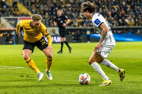 Dynamos Jonas Sterner (l) im Duell mit dem Elversberger Torschützen Nicholas Mickelson. Foto: Britta Pedersen/dpa