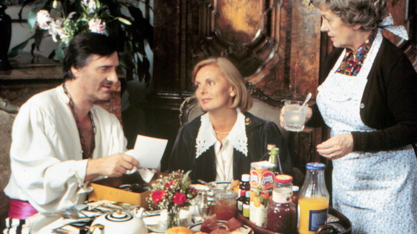 Der "Monaco Franze" (Helmut Fischer) ist im Faschingsfieber – wenig später wird er mit echtem Fieber im Bett liegen. Ehefrau Annette (Ruth Maria Kubitschek, Mitte) und Haushälterin Irmgard (Erni Singerl) sind an seine Spinnereien längst gewöhnt.