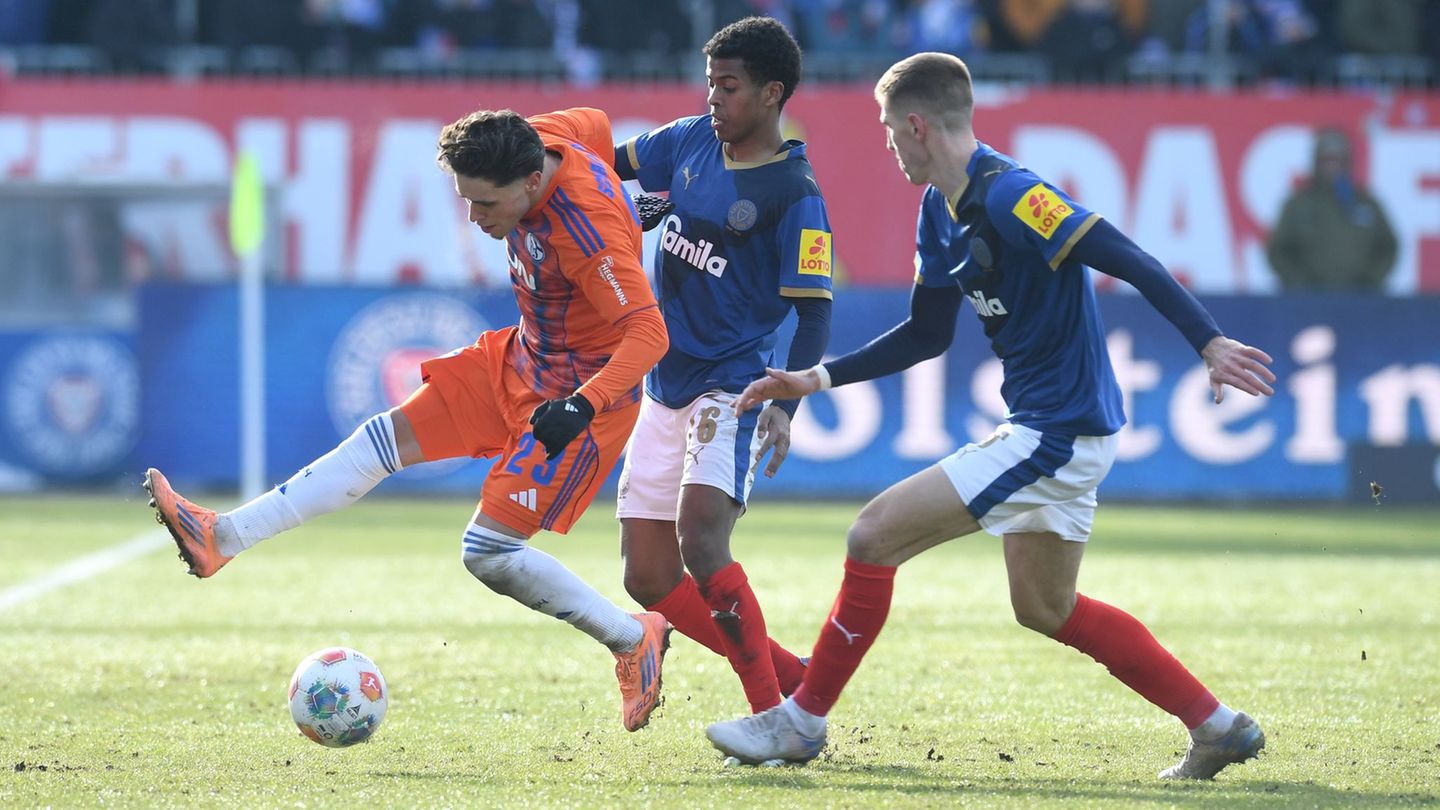 Die Kieler Marko Ivezic und Andu Kelati bedrängen den Schalker Soufiane El-Faouzi. Foto: Daniel Bockwoldt/dpa