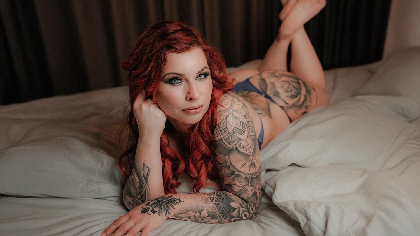 Erotik-Model Chrissi liegt in Unterwäsche auf einem Bett